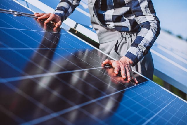 Personne travaillant dans un champ solaire